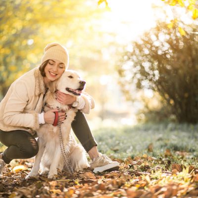 Hund mit Besitzerin im Herbst
